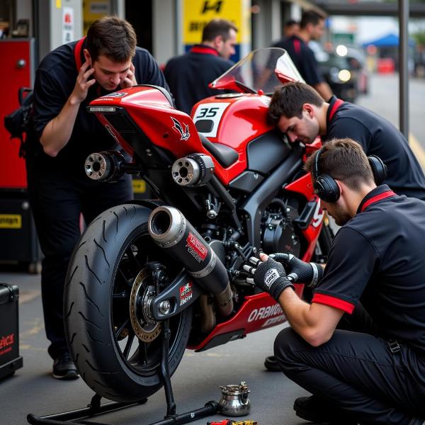 Préparation intense d'une équipe pour les 24h Moto 2024 - Mécaniciens travaillant sur une moto dans le stand, avec des outils et des pièces détachées autour d'eux.