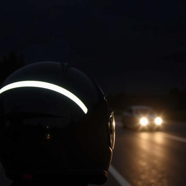 Bande réfléchissante sur un casque moto la nuit améliorant la visibilité du motard.