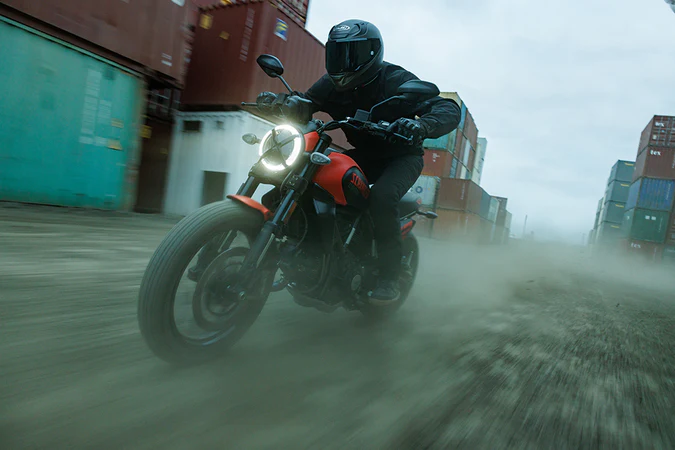 Casque intégrql HJC RPHA 12 Noir Mat porté par un motard dans un décor portuaire