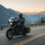 Un motard roule sur une Harley Road Glide sur une route de campagne, avec un paysage montagneux en arrière-plan.