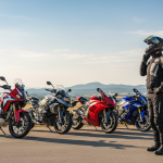 Motard devant différentes motos de marques variées dans un parking.