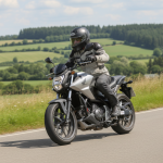 Motard avec une Honda NC750S sur une route de campagne, en plein jour.