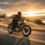 Un motard en équipement moderne pilotant une moto de collection sur une route de campagne.