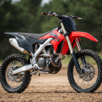 Moto cross Kawasaki KX85 rouge et noire photographiée de trois quarts sur terrain de motocross